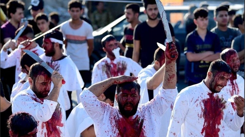 Varios musulmanes chiitas se flagelan con espadas durante el festival religioso de Ashura.