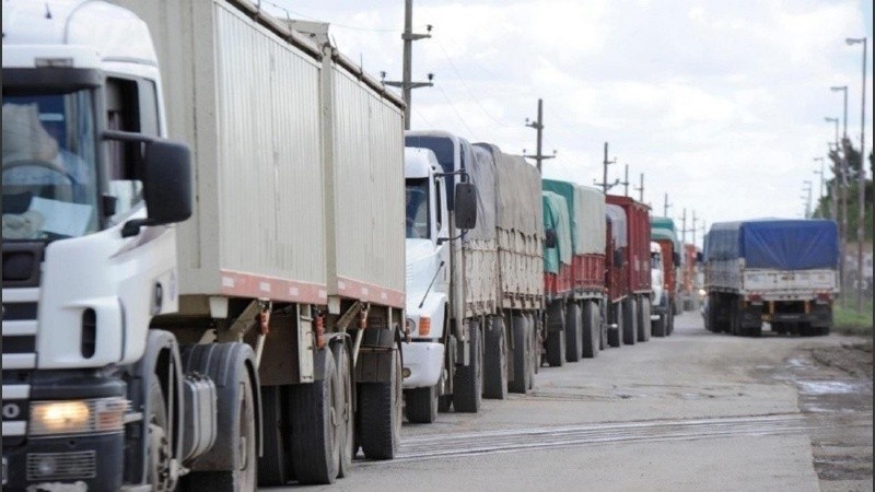 Camiiones atascados transitan en caminos en mal estado para llegar a los puertos cerealeros de punta del Gran Rosario.