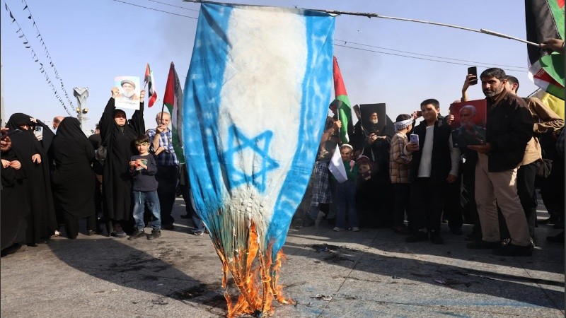 La gente quema una bandera israelí mientras se reúne para una manifestación contra Israel tras un ataque con misiles llevado a cabo por Irán contra Israel la noche anterior, en la plaza Imam Hussein en Teherán, Irán, el 2 de octubre de 2024.