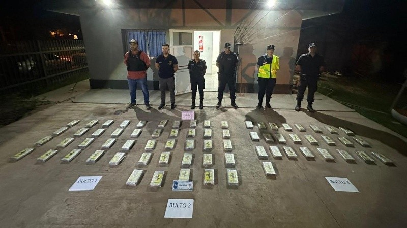 Los agentes policiales con los 70 ladrillos encontrados en tres bultos en la caja de la Toyota Hilux, en el partido de Ramallo.