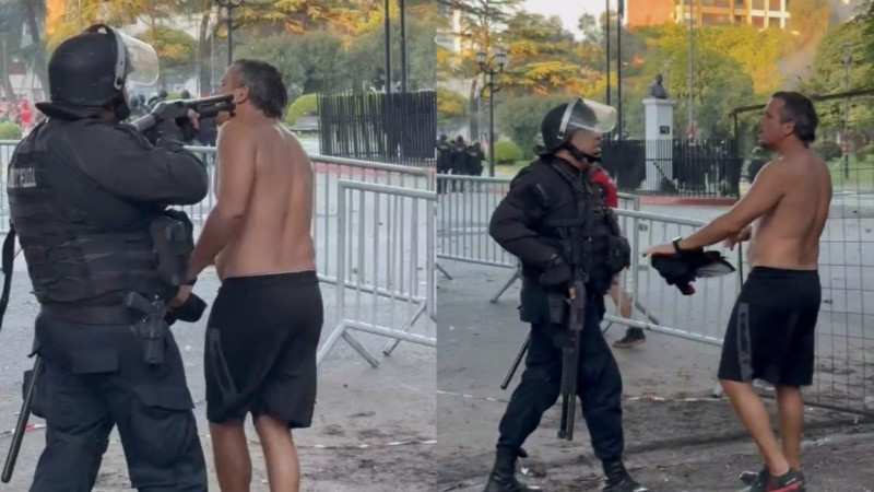 La imagen del agente policial apuntándole en la cabeza al hincha de Newell's.